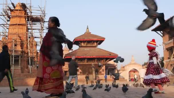 Bhaktapur Kathmandu Nepal October 2018市内広場で鳥を追いかけている子供 舗装されたダーバー広場を走り ハトを追いかける子供 日常生活 地震後の東洋の古代都市 — ストック動画