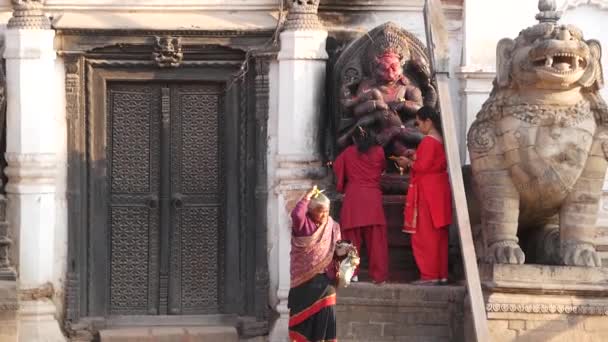 Bhaktapur Kathmandu Nepal October 2018デュルバル王宮のヒンズー教の猿の神ハヌマンを崇拝するために訪れる新しい人々 地震後に一部破壊された宗教的な東洋の古代都市 — ストック動画