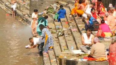 KATHMANDU, NEPAL - 8 Ekim 2018 Sikha Brahman 'la dua ederek yas ayinleri yapıyor. Tonsure Hindu geleneği. Puja. Pashupatinath Tapınağı. Yas tutanlar, hacılar, ghatlarda yakma töreni.