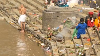 KATHMANDU, NEPAL - 8 Ekim 2018 Sikha Brahman 'la dua ederek yas ayinleri yapıyor. Tonsure Hindu geleneği. Puja. Pashupatinath Tapınağı. Yas tutanlar, hacılar, ghatlarda yakma töreni.