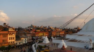 KATHMANDU, NEPAL - 12 Ekim 2018. Boudhanath Stupa ile şehir meydanının panoraması. Himalaya dağlarına karşı güzel bir doğu şehri manzarası. Turistler ve inananlar gün batımında yürüyorlar.