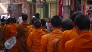BHAKTAPUR, KATHMANDU, NEPAL - 18 Ekim 2018 Genç Budist rahipler geçit töreni bağış toplamak için yürüyor, çocuklar bağış topluyorlar. Günlük sokak hayatı, depremden sonra antik doğu şehri..