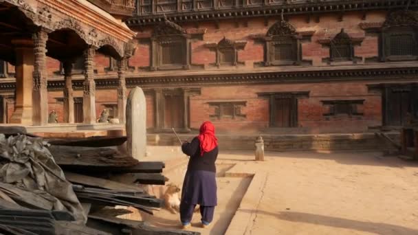 Bhaktapur Kathmandu Nepal October 2018寺院のステップを掃除するシニア女性 カラフルな布ヒンズー教の寺院の屋外の抜本的な階段で高齢者の女性 デュルバル王宮 — ストック動画