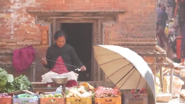 Bhaktapur Nepal 2018年10月13日女人纺纱坐在街上的摊位上 在街上纺线的少数民族妇女坐在摊位上 蔬菜在阳光下出售 — 图库视频影像