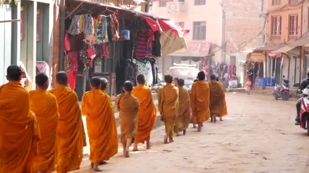 Bhaktapur Kathmandu Nepal October 2018若い仏教の僧侶が施しのために歩くパレード 慈善の申し出を集める子供たち 日常生活 地震後の東洋の古代都市 — ストック動画