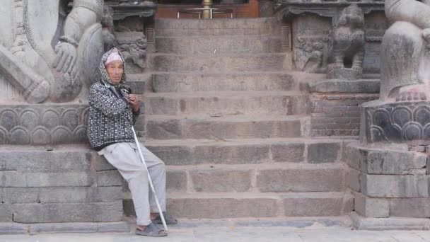 Bhaktapur Kathmandu Nepal October 2018石段の上の貧しい男 老人はヒンズー教の寺院の空の石段に座っています 東日本大震災後の古代都市 — ストック動画