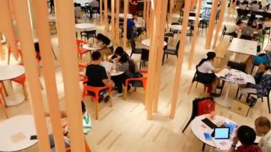 BANGKOK, THAILAND - 26 ARALIK, 2017: Siyam Paragon yemek sahası. İş adamları iş projelerini ve öğrencilerin laptoplarla ve dokümanlarla yuvarlak masalarda ders çalışmalarını tartışıyor. Kamu alanı.