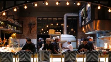 SAMUI, THAILAND - 8 HAZİRAN, 2018: Halka açık mutfağı olan balıkçı plajı restoranı. Aşçılar klasik mekanda çalışıyorlar. Modern kafe ekipmanları. Arka plandaki rahat çubuk.