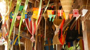 Farklı ülkelerin dekoratif ulusal bayrakları ahşap tropikal bungalovda asılı duruyor. Egzotik Rasta Bar 'ın içi. Tayland 'daki Koh Phangan adasındaki yazlık ev..