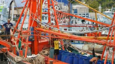 KANOM, THAILAND - 21 Eylül 2018. Kıyıdaki paslı botlar. Balıkçı şehrinde limana park edilmiş eski paslı gemiler. Balıkçı mürekkep balığı endüstrisi. Geleneksel Asya. Deniz kaynaklarının yok edilmesi kavramı.