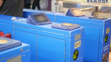 Tren istasyonuna giriş kartı kullanan isimsiz insanlar. Kırpılan insanlar, Skytrain istasyonuna girerken turnikelerde plastik araba kullanıyorlar.