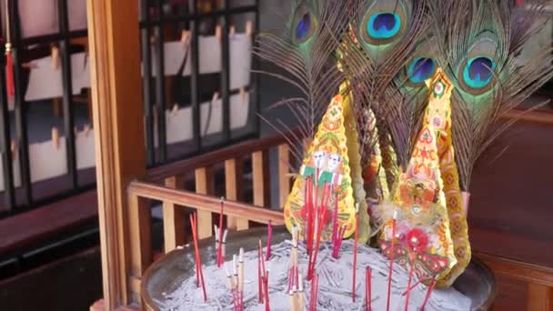 伝統的な祭壇に香と羽 芳香族香棒と美しい孔雀の羽は 東洋エキゾチックなタイの伝統的な中国の祭壇の上にボウルに詰め — ストック動画