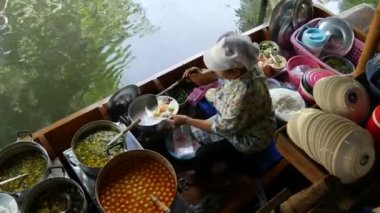 BANGKOK, THAILAND, 13 HAZİRAN 2019 Lat Mayom yüzer pazarı. Geleneksel Khlong nehir kanalı, uzun kuyruklu yerli kadınlar ve oryantal Thai küfretme türleri. İkonik Asya sokak yemekleri satıyor.