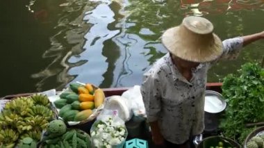 BANGKOK, THAILAND - 13 HAZİRAN 2019: Geleneksel Khlong nehir kanalı, yerel kadın çiftçiler, meyve ve sebzeli uzun kuyruklu tekneler. İkonik Asya sokak yemekleri satıyor.