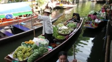 BANGKOK, THAILAND - 13 HAZİRAN 2019: Geleneksel Khlong nehir kanalı, yerel kadın çiftçiler, meyve ve sebzeli uzun kuyruklu tekneler. İkonik Asya sokak yemekleri satıyor.