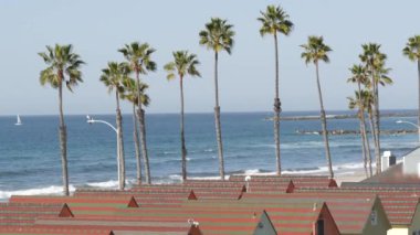 Oceanside California USA 'deki kulübeler. Deniz kenarındaki bungalovlar. Okyanus sahili palmiyeleri. Yaz deniz manzarası.