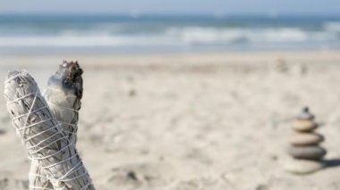 Okyanus sahilinde kaya dengesi, deniz dalgaları tarafından istiflenen taşlar. Çakıl taşı piramidi, adaçayı lekesi çubuğu.