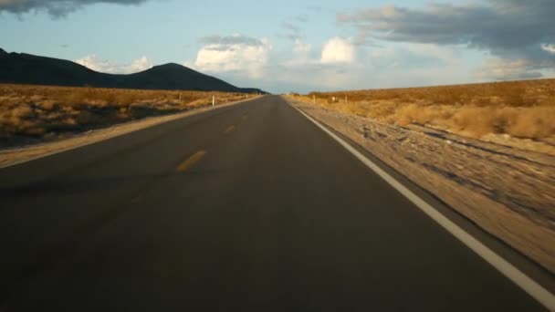 Viaje por carretera, conduciendo auto desde Death Valley a Las Vegas, Nevada, EE.UU. Hacer autostop viajando por América. Viaje por carretera, atmósfera dramática, montaña al atardecer y desierto de Mojave. Vista desde el coche — Vídeos de Stock