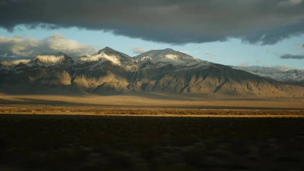 Road trip, driving auto from Death Valley to Las Vegas, Nevada USA. Hitchhiking traveling in America. Highway journey, dramatic atmosphere, sunset mountain and Mojave desert wilderness. View from car — Stock Photo, Image