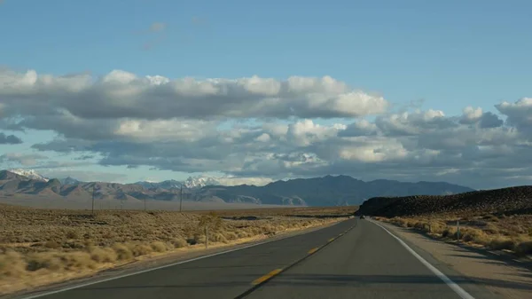 Road trip, auto rijden van Death Valley naar Las Vegas, Nevada USA. Liften op reis in Amerika. Highway reis, dramatische sfeer, wolk, berg en Mojave woestijn wildernis. Zicht vanuit auto — Stockfoto