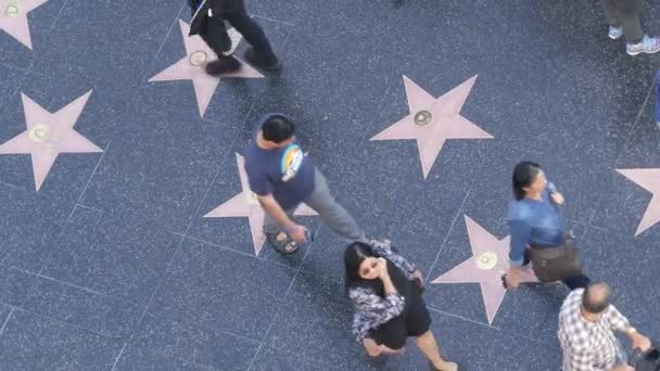 Los Angeles California 11月2019 ロサンゼルスのハリウッド大通りにある名声遊歩道の散歩 アスファルトの有名人の星の近くを歩く歩行者 ドルビーとTcl中華劇場の近くのウォークウェイフロア — ストック動画