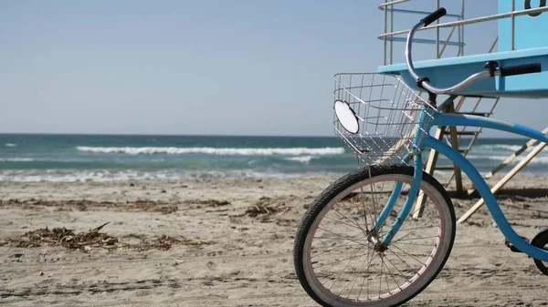 Bicycle cruiser bike by ocean beach California coast USA. Summer sea shore. Cycle by lifeguard tower