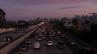 SAN DIEGO, CALIFORNIA USA - 15 HAZİRAN 2020: yoğun şehirlerarası otoyol, yoğun saatlerde otoyolda trafik sıkışıklığı. Şehir silueti, gökdelen ve iniş uçağı. Uçan uçak, ulaşım konsepti.