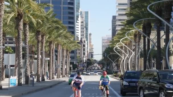 カリフォルニア州サンディエゴ 2020年1月4日 ダウンタウンの大都市での男性自転車 現代の高層ビルの間で自転車をサイクリング男性 ブロードウェイ通りの近代的な高層ビル — ストック動画