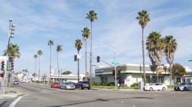 Oceanside, California USA - 27 Ocak 2020: 101 numaralı otoyoldaki palmiye ağaçları, Pasifik sahili tropikal caddesi. Trafik ışığı ve otomobil kavşakta, arabalar banliyöde kavşakta..