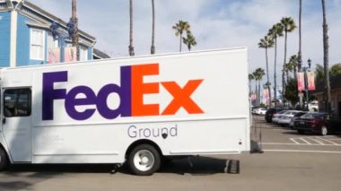 Oceanside, California USA - 27 Ocak 2020: Polis şerifi arabası, Pier View Coffee cafe. Tipik Amerikan caddesinde palmiye ağaçları, Pasifik kıyısı tropik tatil beldesi. FedEx kamyonet kamyonu, şehrin genel manzarası.
