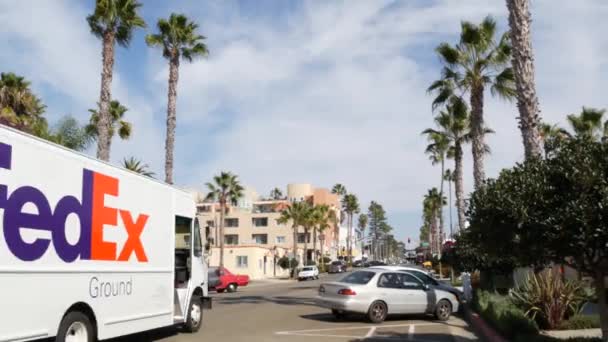 Oceanside, California USA - 27 Jan 2020: Pohon palem di jalan khas Amerika, resor tropis pantai pasifik. Transportasi otomatis di jalan, pemandangan kota generik. FedEx jasa pengiriman truk, mobil pos ...
