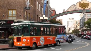 SAN DIEGO, CALIFORNIA USA - 30 HAZİRAN 2020: 5. Cadde 'deki Gaslamp Quarter tarihi giriş işareti. Turuncu ikonik retro tramvay, atlama otobüsü ve turistik yer, Eski Şehir Turu..