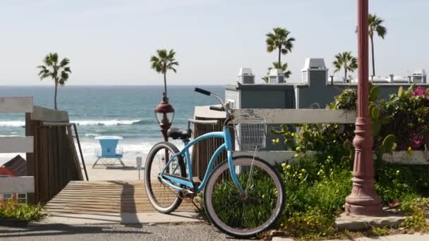 Bicicleta de crucero en bicicleta por la playa del océano, costa de California EE.UU.. Ciclo de verano, escaleras y palmeras. — Vídeo de stock