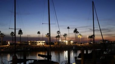 Yat, yat limanında yelkenli. Yelkenli gemi alacakaranlıkta kalkıyor. Kaliforniya, ABD 'de hava karardı..