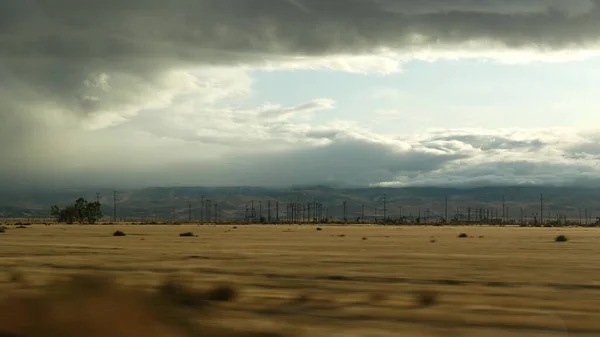 Driving auto, road trip in California, USA, view from car. Hitchhiking traveling in United States. Highway, mountains and cloudy dramatic sky before rain storm. American scenic byway. Passenger POV