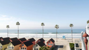 Oceanside California USA 'deki kulübeler. Deniz kenarındaki bungalovlar. Okyanus sahili palmiyeleri. Cankurtaran kulesi.