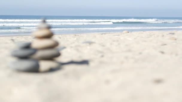 Kamień balansujący na plaży oceanicznej, kamienie układające się przy morskich falach wodnych. Piramida kamieni na piaszczystym brzegu — Wideo stockowe