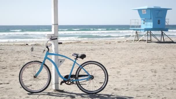 Bicicleta crucero en bicicleta por la playa del océano costa de California EE.UU.. Playa de verano. Ciclo por torre de salvavidas — Vídeos de Stock