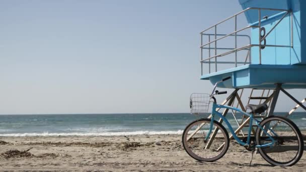 海のビーチによる自転車巡洋艦自転車｜カリフォルニア海岸USA。夏の海岸。ライフガードタワーによるサイクル — ストック動画