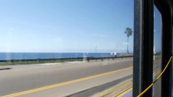 Окно автобуса, тихоокеанское побережье, автострада 101, Калифорния, США. Дорожное путешествие вдоль летнего океана или моря. — стоковое видео