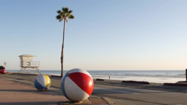 Oceaanstrand Californië USA. Bal, strandwachttoren, strandwachttoren hut, palmboom aan het strand. — Stockvideo