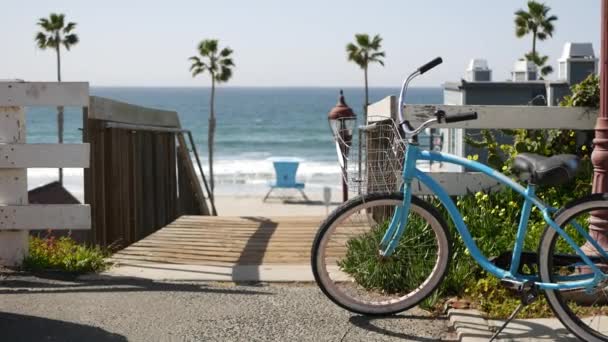 Bicycle cruiser bike by ocean beach, California coast USA. Summertime cycle, stairs and palm trees. — Stock Video
