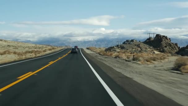 Viaje por carretera a Death Valley, conduciendo un auto en California, EE.UU. Hacer autostop viajando por América. Carretera, montañas y desierto seco, árido clima salvaje. Punto de vista del pasajero del coche. Viaje a Nevada — Vídeo de stock