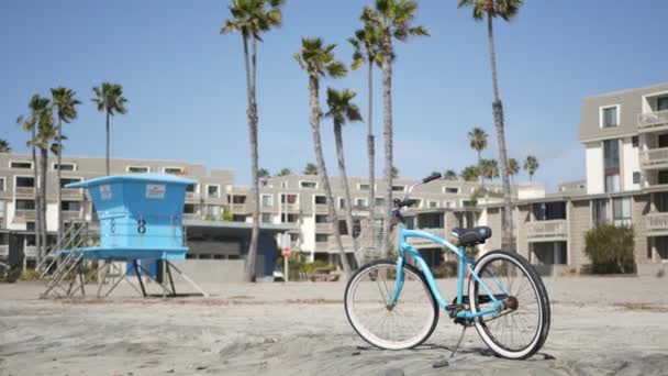 Vélo de croisière à vélo par la plage de l'océan, côte californienne États-Unis. Cycle d'été, maisons et palmiers. — Video
