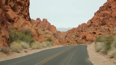 Araba gezisi, Ateş Vadisi, Las Vegas, Nevada, ABD. Amerika 'da otostop çekmek, otoban yolculuğu. Kızıl uzaylı kaya oluşumu, Mojave çölü vahşi doğası Mars 'a benziyor. Arabadan görüntüle