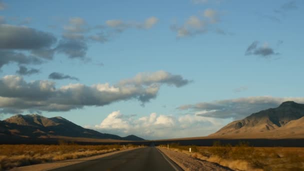 Podróż samochodem z Doliny Śmierci do Las Vegas w stanie Nevada. Podróżując autostopem po Ameryce. Podróż autostradą, dramatyczna atmosfera, zachód słońca i pustynia Mojave. Widok z samochodu — Wideo stockowe