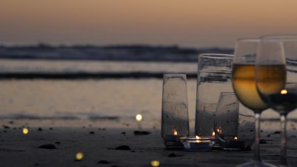 Candle flame lights in glass, romantic beach date by ocean waves, summer sea. Candlelight on sand. — Stock Video