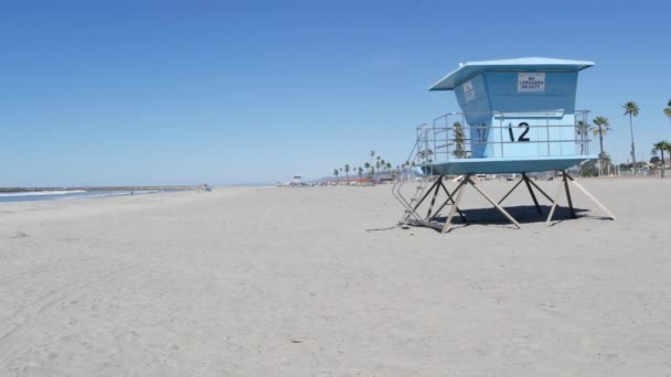Palmy na białej, piaszczystej plaży, wybrzeże oceanu w Kalifornii. Wieża ratownicza, chata strażnicza. — Wideo stockowe