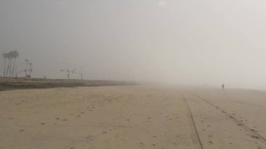 Sandy sisli Kaliforniya plajı. Pasifik Okyanusu kıyılarında yoğun sis var. Süt buğulu sis bulutu