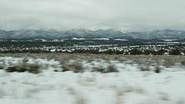 Road trip aux États-Unis de Zion à Bryce Canyon, en voiture dans l'Utah. Voyage en auto-stop en Amérique, Route 89 vers la forêt de Dixie. Voyage local d'hiver, atmosphère calme et montagnes de neige. Vue de la voiture — Photo